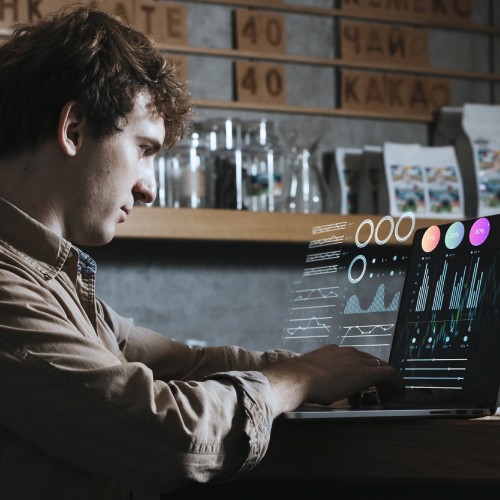 Man working on a laptop with charts in an office